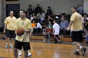 Adults playing basketball in a gym.