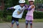Young Rollerbladers Helping Each Other